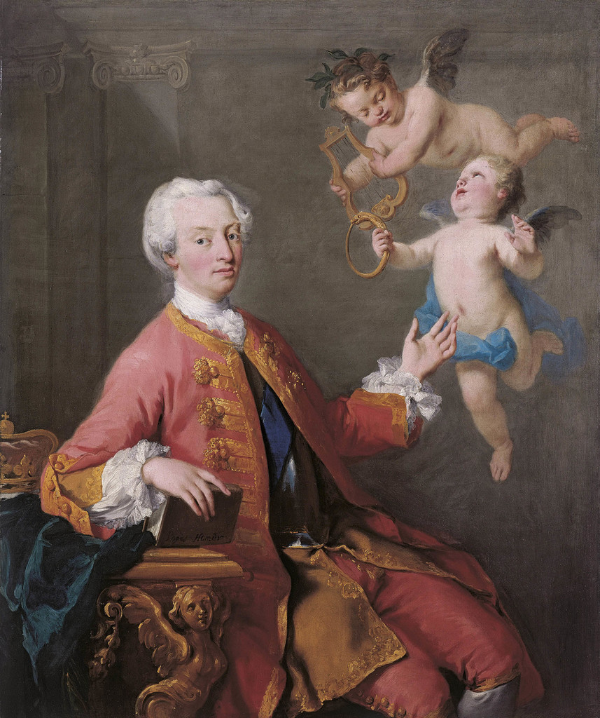 A three-quarter length portrait of Frederick Prince of Wales, seated, facing to the right. He wears a powdered wig, a red frock coat with lace cuffs and gold braid embellishments, and matching red breeches. One elbow leans on a table supported by a carved angel; a crown is just visible behind his arm. the other hand gestures to two floating cherubs above him, one holding a hoop and the other a lyre.