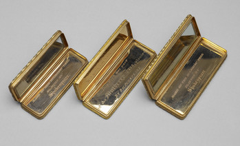 Three gold-trimmed rectangular boxes, each open at the hinge to display a mirrored lining. Two of them have inscriptions reading 'Made of the Mulberry Tree planted by Shakespeare'. The central box has the inscription "This Wood was part of the Mulberry Tree planted by Shakespeare."